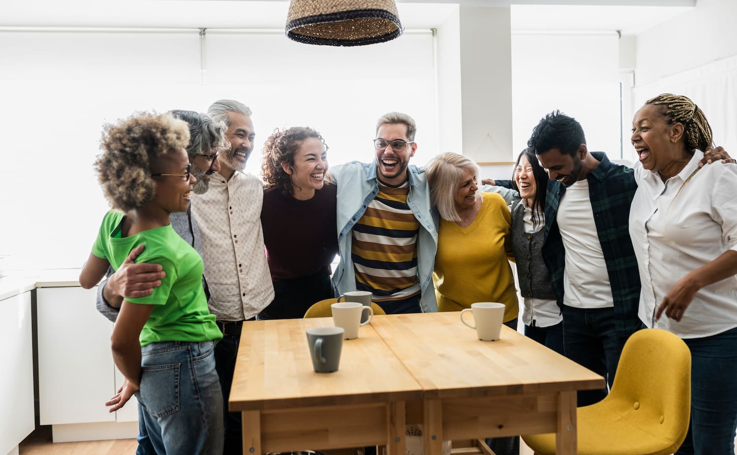 multigenerational homes group of laughing family members surrounding kitchen table